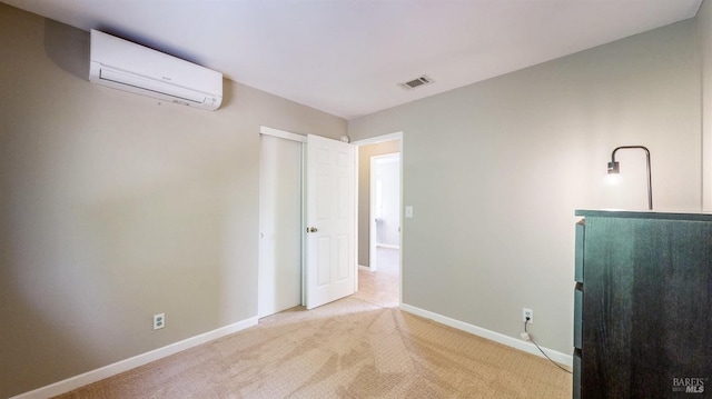 unfurnished bedroom with light carpet, visible vents, baseboards, an AC wall unit, and freestanding refrigerator