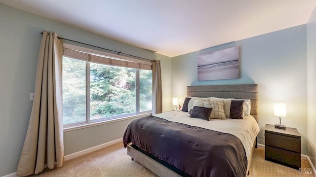 bedroom featuring baseboards and light colored carpet