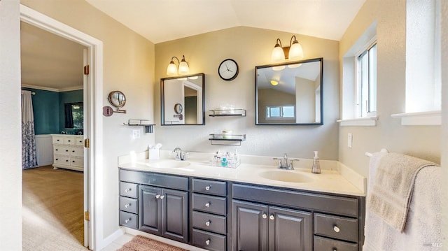 bathroom with lofted ceiling, double vanity, and a sink