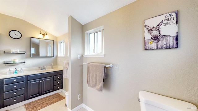 bathroom featuring vaulted ceiling, vanity, toilet, and baseboards