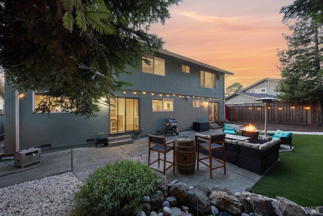 back of property with entry steps, fence, stucco siding, a patio area, and an outdoor living space with a fire pit