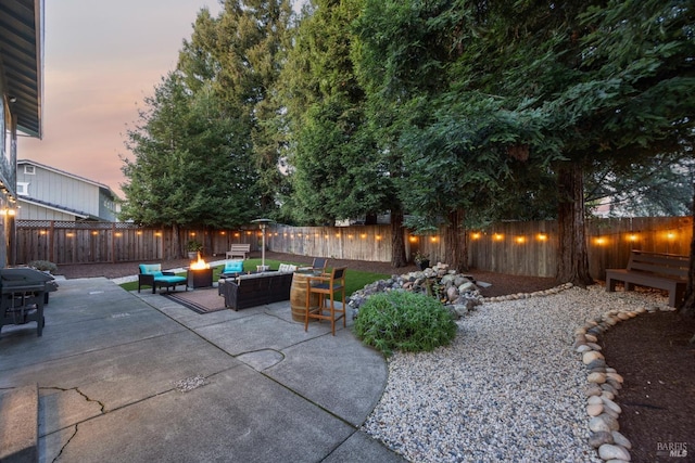 view of patio / terrace with a fenced backyard and an outdoor living space with a fire pit