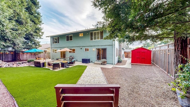 back of property with an outdoor living space with a fire pit, a fenced backyard, an outbuilding, a storage unit, and a patio area