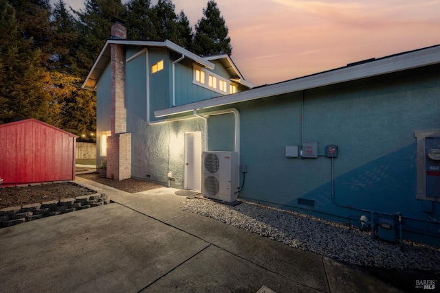 back of property featuring a patio, ac unit, crawl space, a storage unit, and a chimney