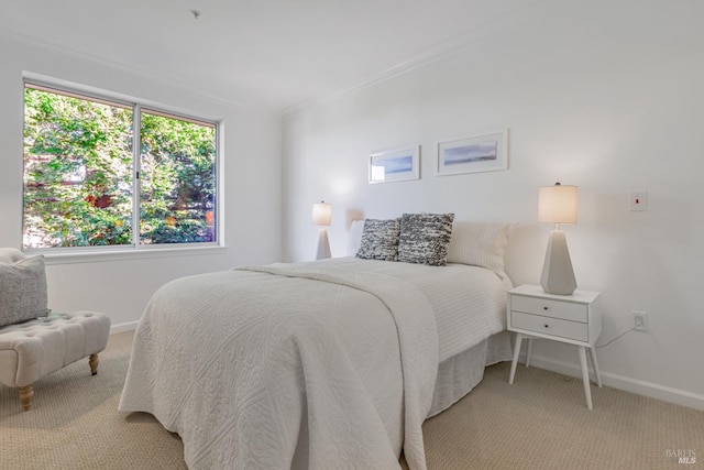 bedroom with light carpet, crown molding, and baseboards