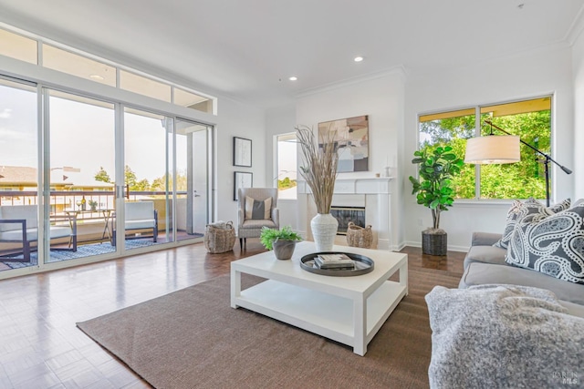 living room with a wealth of natural light, a glass covered fireplace, baseboards, and recessed lighting