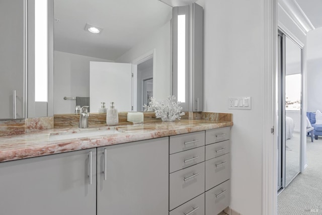 bathroom with a wealth of natural light, connected bathroom, and vanity