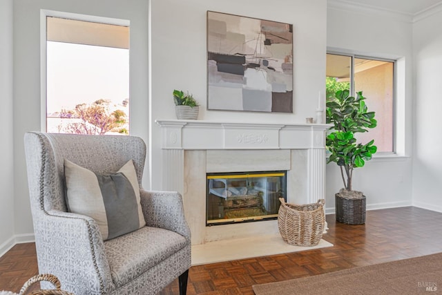 sitting room featuring a premium fireplace, baseboards, and crown molding