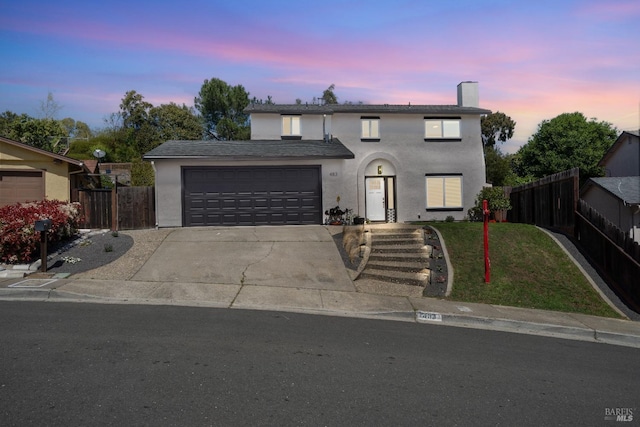traditional-style house with a front lawn, fence, a garage, and concrete driveway