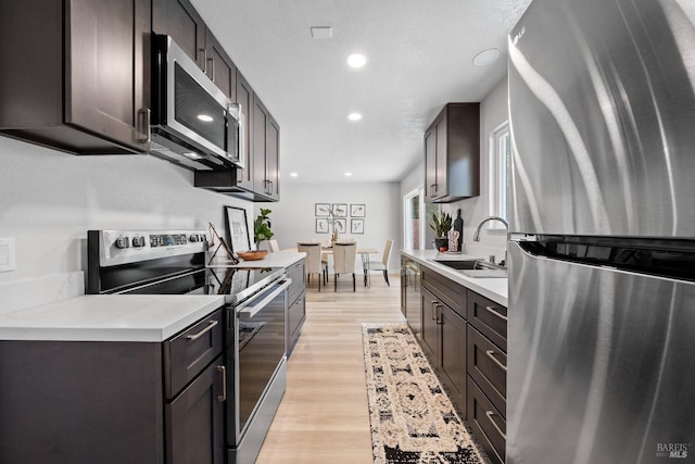 483 Rinconada Ct, Benicia, CA 94510 - kitchen with appliances with stainless steel finishes, a sink, light countertops, light wood-type flooring, and dark brown cabinets