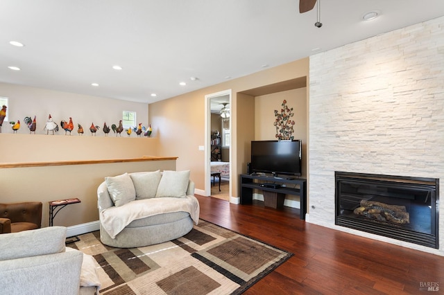 living room with a fireplace, baseboards, a ceiling fan, and wood finished floors