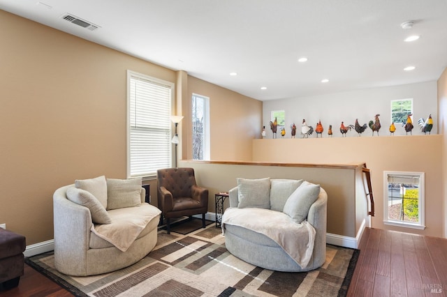 living area featuring recessed lighting, visible vents, baseboards, and wood finished floors