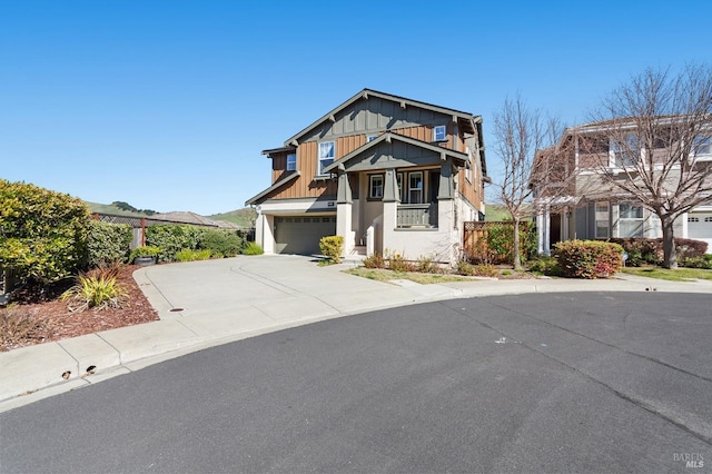 craftsman inspired home with board and batten siding, concrete driveway, fence, and a garage