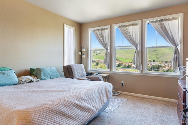 bedroom with light carpet and baseboards