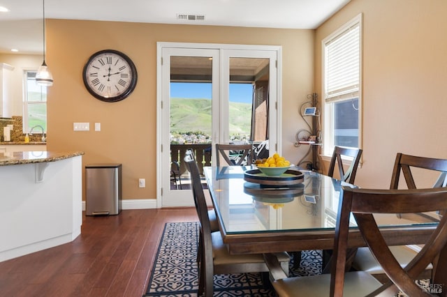 dining area featuring dark wood-style floors, visible vents, and baseboards