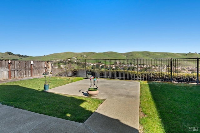 view of yard featuring fence private yard, a patio area, and a mountain view