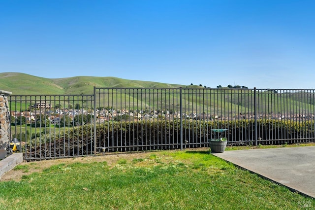 view of yard with a rural view, fence, and a mountain view