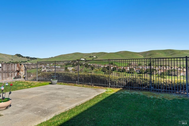 view of yard with a patio area, fence, and a mountain view