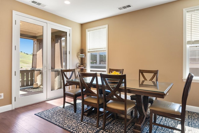 dining area featuring a healthy amount of sunlight, visible vents, and wood finished floors