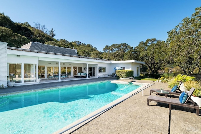 pool with a patio and a diving board