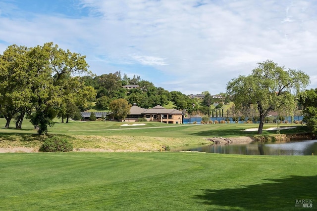 view of home's community featuring a yard, golf course view, and a water view