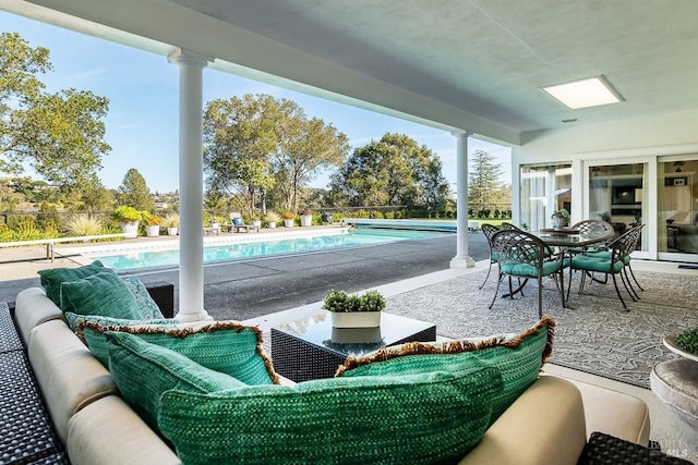 view of patio / terrace with a fenced in pool, outdoor dining space, and an outdoor living space