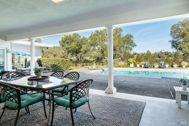 view of patio featuring a fenced in pool, outdoor dining space, and fence