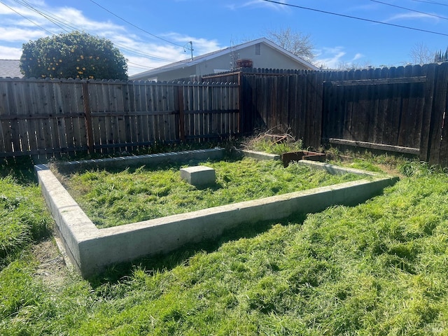 view of yard featuring a garden and a fenced backyard