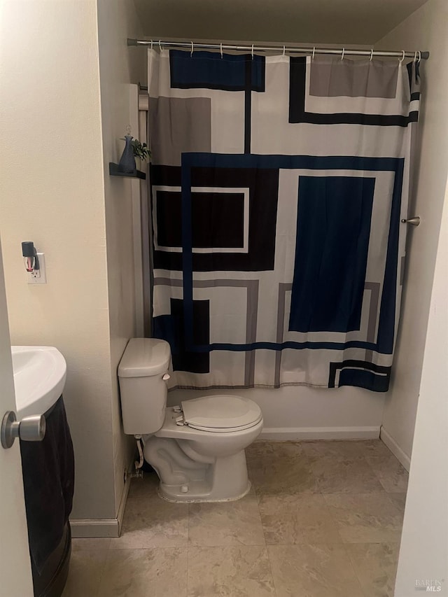 bathroom featuring toilet, curtained shower, and baseboards