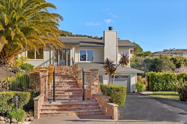 view of front of property featuring driveway and a chimney