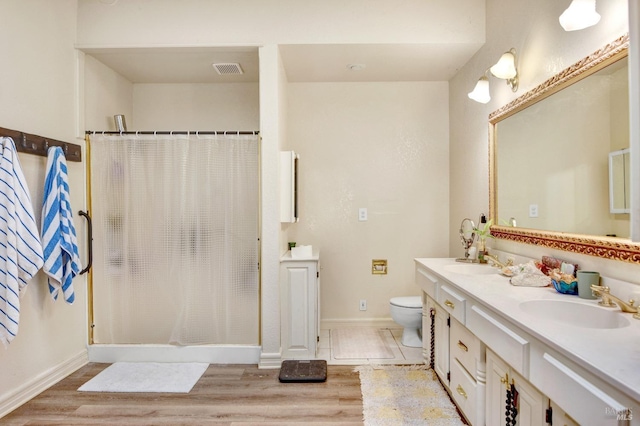 full bathroom featuring toilet, visible vents, a sink, and wood finished floors