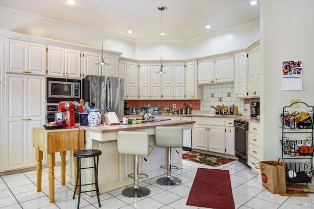 kitchen featuring a kitchen island, white cabinetry, light countertops, appliances with stainless steel finishes, and decorative backsplash