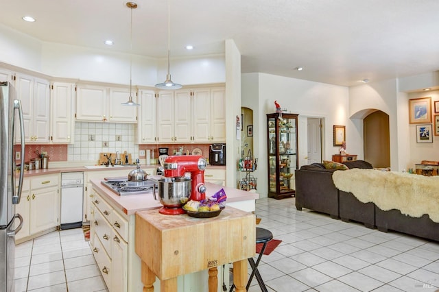 kitchen featuring open floor plan, light countertops, arched walkways, and a kitchen island