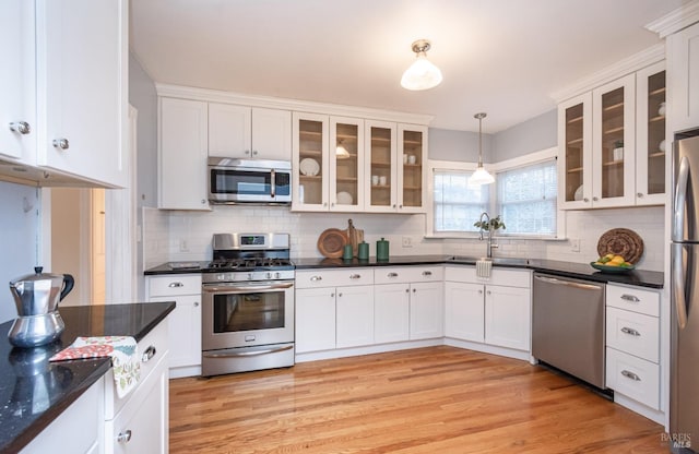 kitchen with dark countertops, light wood-style flooring, and appliances with stainless steel finishes