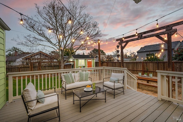 wooden terrace featuring an outbuilding, fence, and an outdoor living space