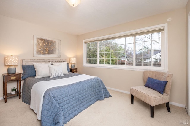 bedroom featuring baseboards, multiple windows, and light colored carpet