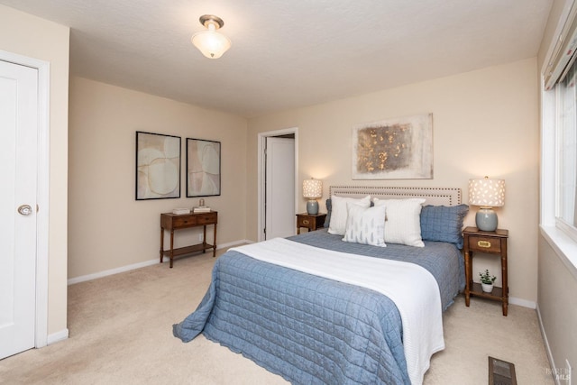 bedroom featuring baseboards, visible vents, and light colored carpet