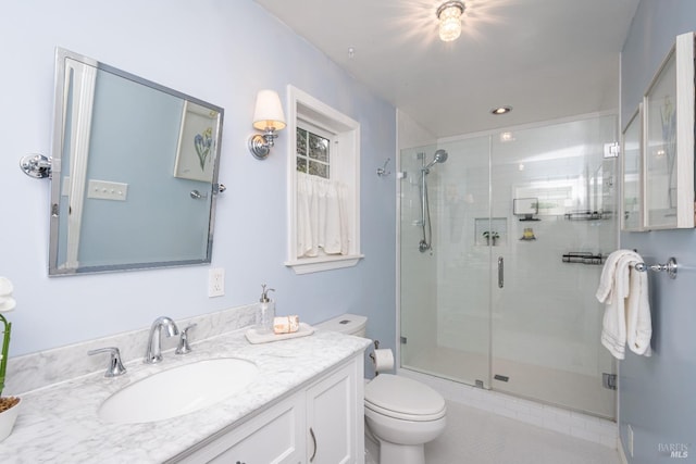 bathroom featuring toilet, a shower stall, and vanity