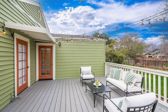 wooden terrace featuring outdoor lounge area and fence