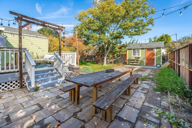 view of patio featuring an outbuilding, a deck, and a fenced backyard