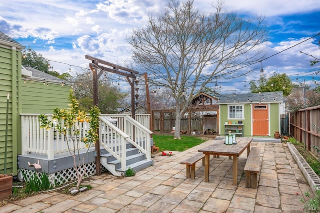 view of patio featuring a fenced backyard, a shed, a deck, and an outdoor structure