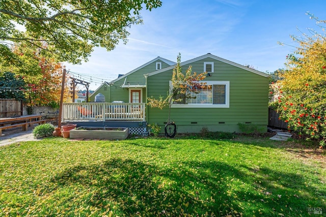 back of house featuring a yard, crawl space, fence, and a wooden deck