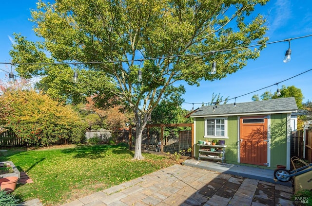 view of yard with a patio area, a fenced backyard, and an outdoor structure