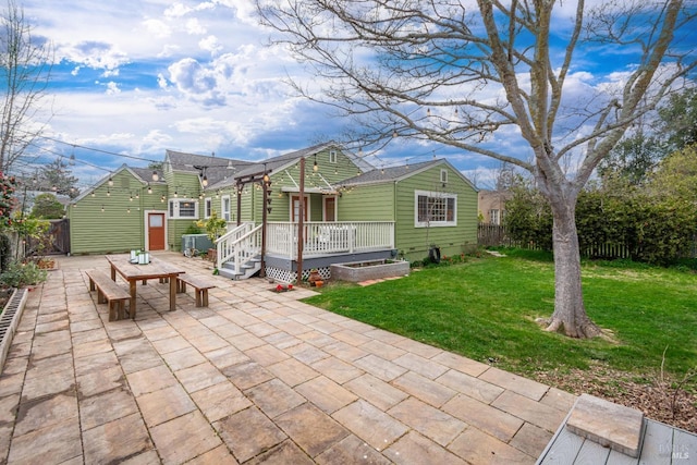 view of front of house featuring a patio, a wooden deck, a front lawn, and fence