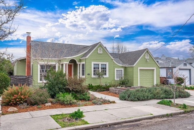 view of front of house featuring an attached garage, a shingled roof, fence, driveway, and a chimney