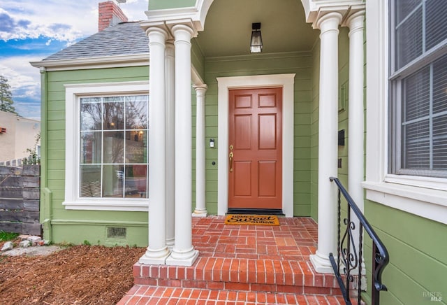 entrance to property with roof with shingles, crawl space, and a chimney