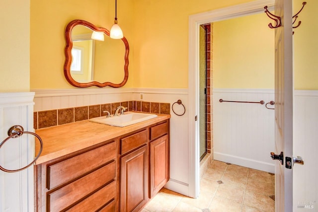 bathroom featuring a wainscoted wall, tile patterned flooring, vanity, and a shower with door