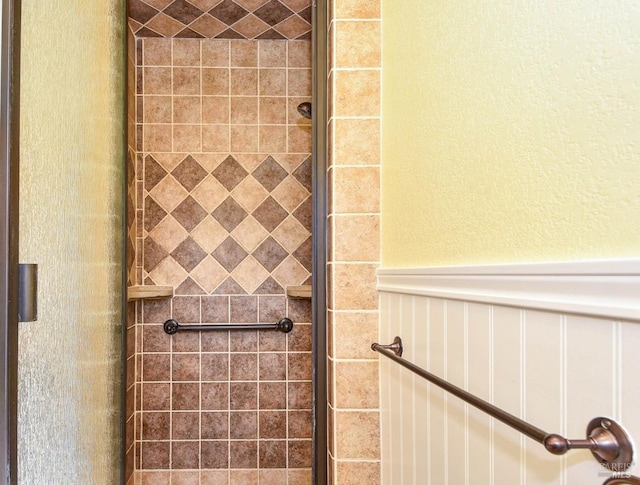 bathroom with a stall shower and wainscoting