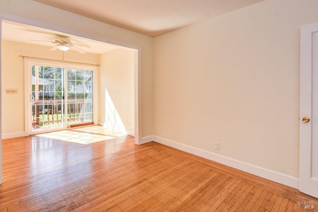 empty room with a ceiling fan, light wood-type flooring, and baseboards