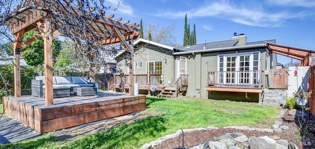 rear view of house with a chimney, a lawn, an outdoor living space, and a wooden deck